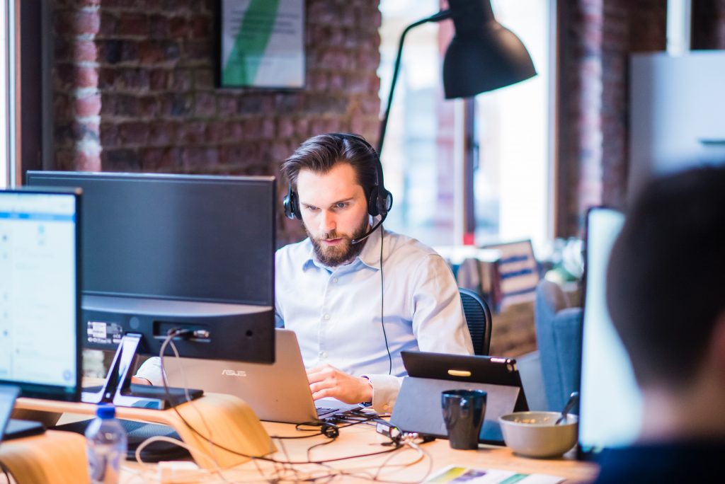 A man with a phone at a call center making money during the pandemic