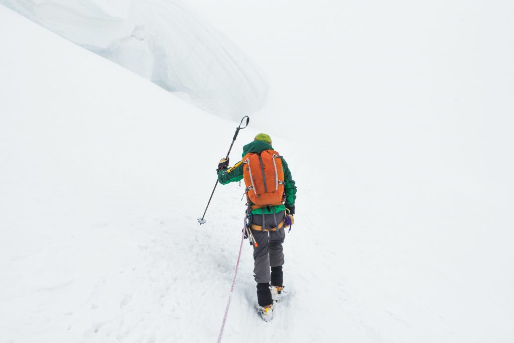 person walking up a snowy mountain