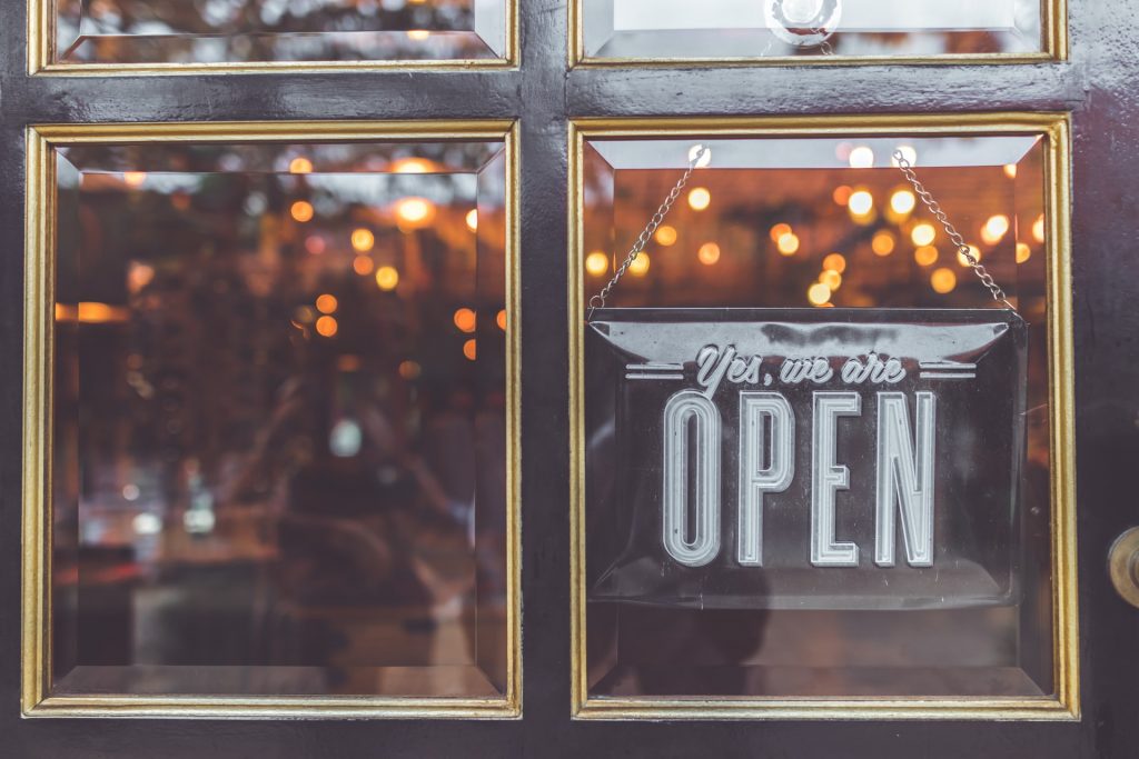 "Yes, we are OPEN" sign on a business door