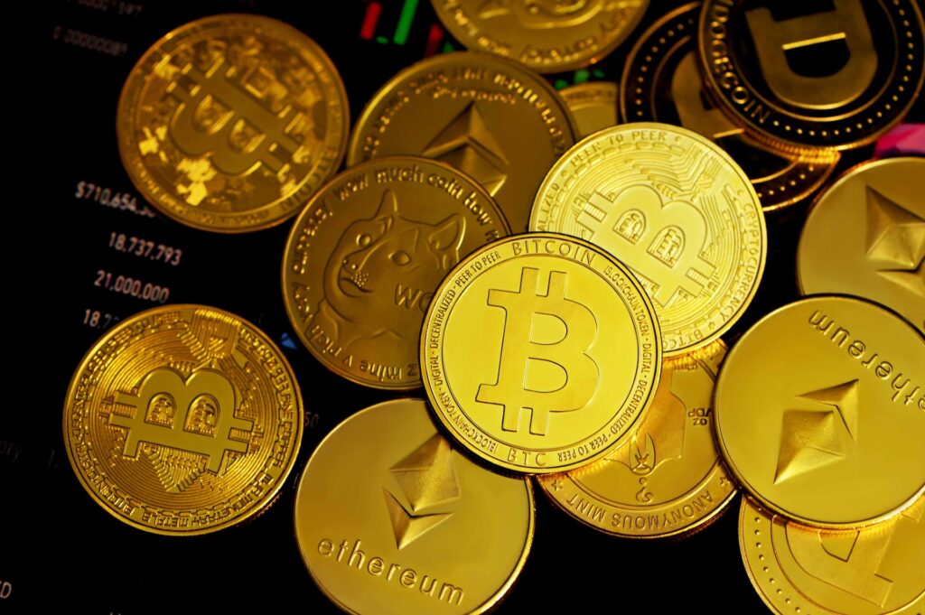 Image of a bunch of gold coins with cryptocurrency logos on them